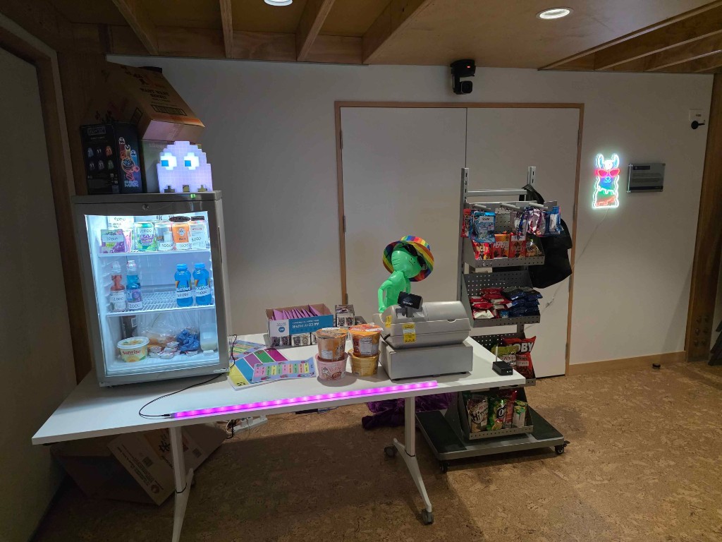 EggCamp snack bar setup with drinks, noodles, and neon lights.